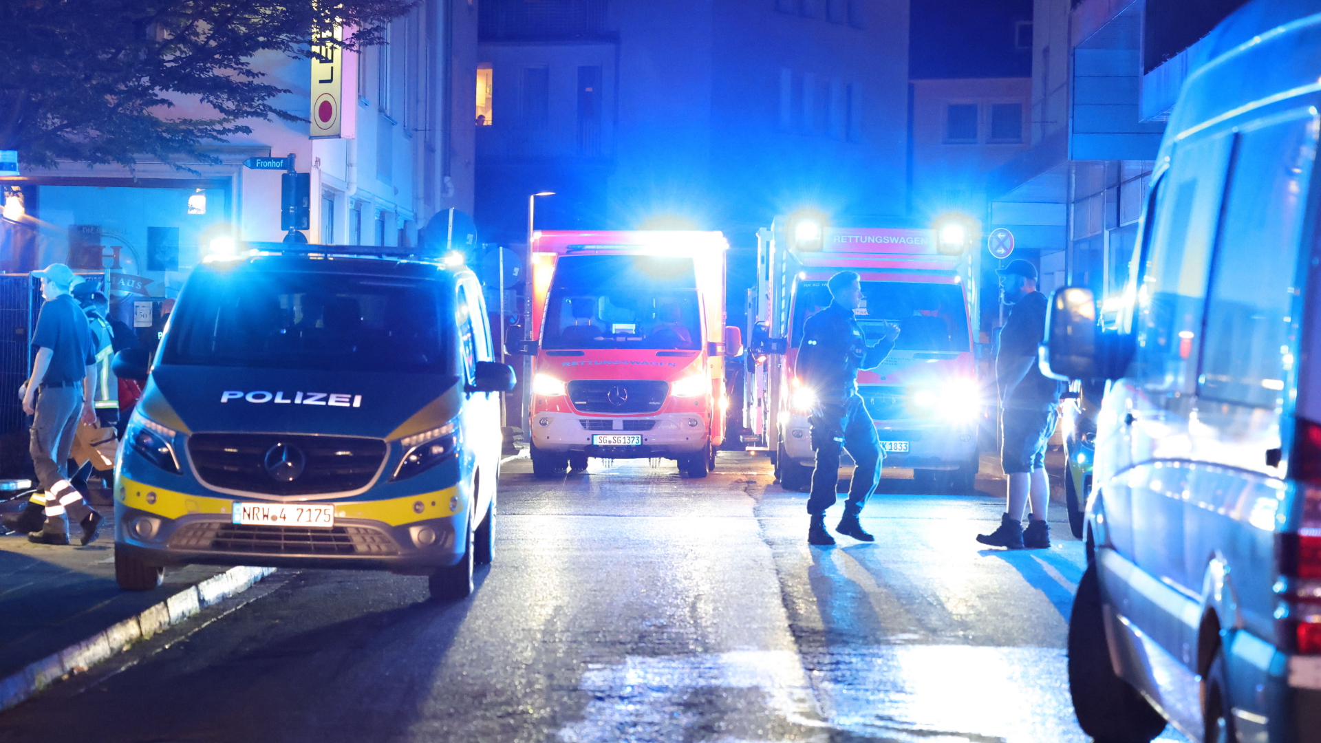 23.08.2024, Nordrhein-Westfalen, Solingen: Polizei und Rettungswagen stehen in der Nähe des Einsatzortes. Bei einer Attacke auf der 650-Jahr-Feier der Stadt hat es Todesopfer und Verletzte gegeben. Die Tatwaffe sei mutmaßlich ein Messer gewesen, hieß es aus Polizeikreisen. Die Polizei löste Großalarm aus. Foto: Gianni Gattus/dpa +++ dpa-Bildfunk +++